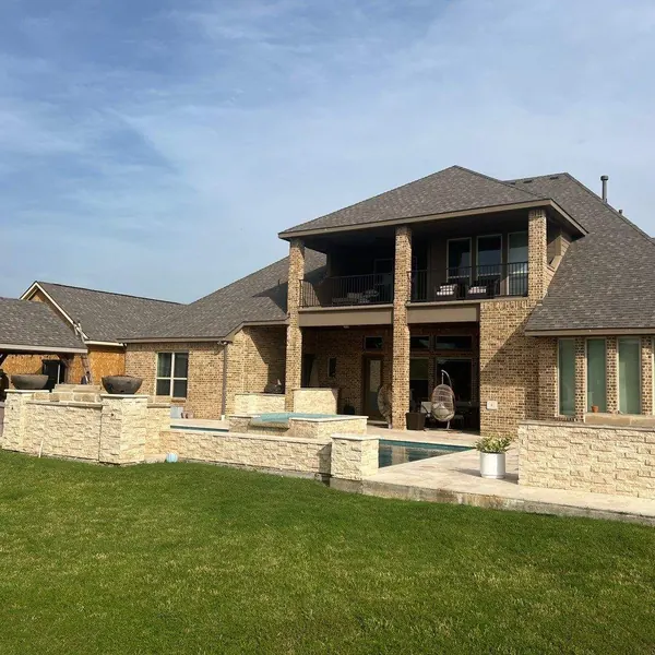 Two-story stone home with covered balcony